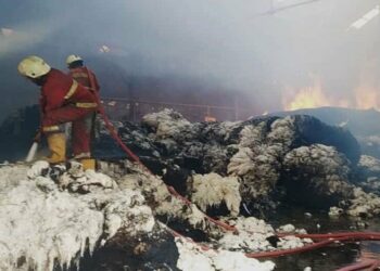 PADAMKAN API : Petugas Pemadam Kebakaran menyemporkan air untuk memadamkan api di gudang milik PT Argo Pantes Kota Tangerang, Sabtu (1/8). (ISTIMEWA)