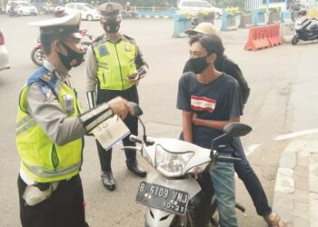 TILANG: Petugas Polres Metro Tangerang Kota Tengah menilang
pengendara motor yang tak menggunakan helm saat berkendara. (IRFAN/SATELIT NEWS)