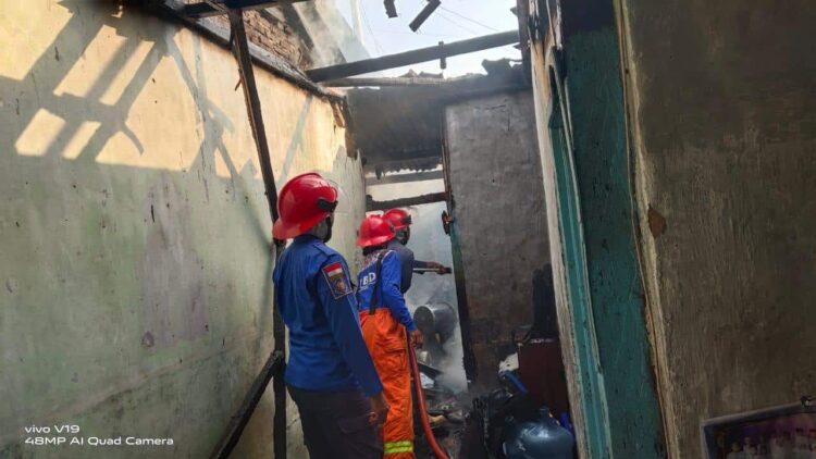 PEMADAMAN - Petugas Damkar sedang melakukan pamadaman api, di lokasi kebakaran, Minggu (27/6). (SIDIK/SATELIT NEWS)