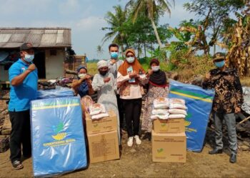BANTU KORBAN KEBAKARAN–Pegawai Dinsos Kabupaten Pandeglang, menyerahkan bantuan kepada para korban kebakaran di Desa Panimbangjaya, Kecamatan Panimbang, Kabupaten Pandeglang, Jumat (30/7/2021). (ISTIMEWA)