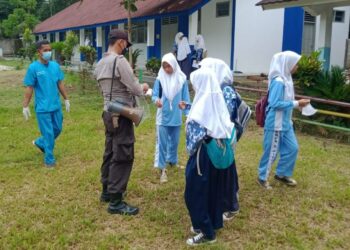 BAGIKAN MASKER–Jajaran personel Polsek Jiput, membagikan masker sambil mengimbau disiplin Prokes, di lapangan SMP Negeri 2 Jiput, Kamis (21/10/2021). (ISTIMEWA)