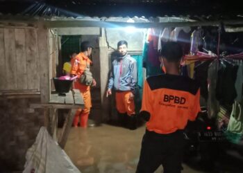 Anggota BPBD Kabupaten Serang monitoring lokasi banjir, yang diakibatkan meluapnya air Sungai Cikalumpang. (ISTIMEWA)