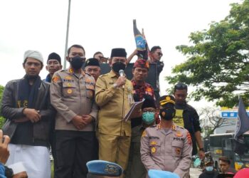 Asda I Pemkab Serang, Nanang Supriatna, menaiki mobil komando untuk menyampaikan pernyataan mengenai rencana pembongkaran THM di JLS, Selasa (30/11/2021). (ISTIMEWA)