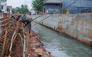 REVITALISASI: Para pekerja sedang melakukan pekerjaan revitalisasi sungai yang melintasi kawasan Reni Jaya Kecamatan Pamulang.