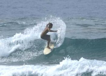 Seorang peserta, sedang berselancar dalam lomba surfing yang diadakan oleh Disporapar Kabupaten Serang, Rabu (8/12/2021). (ISTIMEWA)