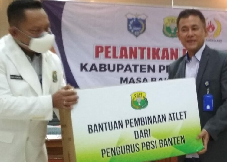 Ketua Umum PBSI Pengprov Banten (kiri), serahkan bantuan kepada Ketua Umum Pengkab Pandeglang, usai pelantikan pengurus PBSI Pandeglang, di Opproom Setda setempat, Kamis (20/1/2022). (MARDIANA/SATELITNEWS.ID)