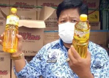 Kepala Diskopumindag Kabupaten Serang, Adang Rahmat (kanan), menunjukan minyak goreng yang dijual pada OP di Ciruas, belum lama ini. (ISTIMEWA)