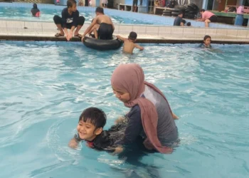 WISATA KOLAM RENANG–Seorang anak sedang belajar berenang, di salah satu objek wisata kolam renang, di Kabupaten Pandeglang, Minggu (13/3/2022). (NIPAL SUTIANA/SATELITNEWS.ID)
