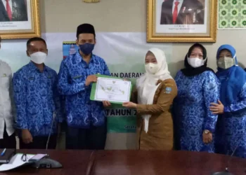 Plt Kepala DPKD Kabupaten Serang, Anas Diwsatya Prasadya, menyerahkan dokumen akreditas kepada salah satu sekolah. (ISTIMEWA)