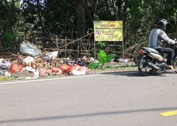Sampah terlihat menumpuk dan berserakan di pinggir Jalan Raya AMD Lintas Timur Pandeglang, padahal terpangpang papan larangan buang sampah, Senin (16/5/2022). (ISTIMEWA)