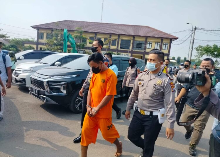 Sopir Odong-odong (kaos oranye), di kawal menuju tahanan Mapolda Banten, Rabu (27/7/2022). (ISTIMEWA)