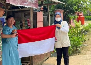 Pihak Puskesmas bersama Muspika Kecamatan Patia, Kabupaten Pandeglang, sedang memberikan bendera merah putih ke warga setempat, Kamis (4/8/2022). (ISTIMEWA)