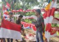 Para penjual bendera, di Jalan Raya Pandeglang-Labuan, tepatnya di Gardu Tanjak Kecamatan Pandeglang, sedang melayani pembeli, Minggu (14/8/2022). (NIPAL SUTIANA/SATELITNEWS.ID)
